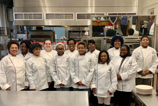 High school students serving as nutrition ambassadors wear chef coats.