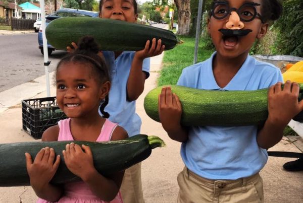 Girls holding large zucchini