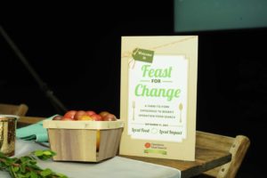 program and basket of tomatoes at Feast for Change event