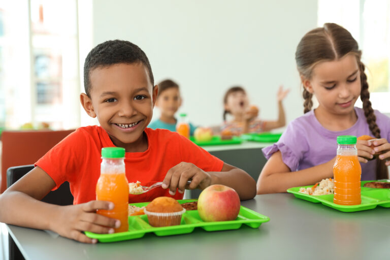 Happy kids eating lunch at school